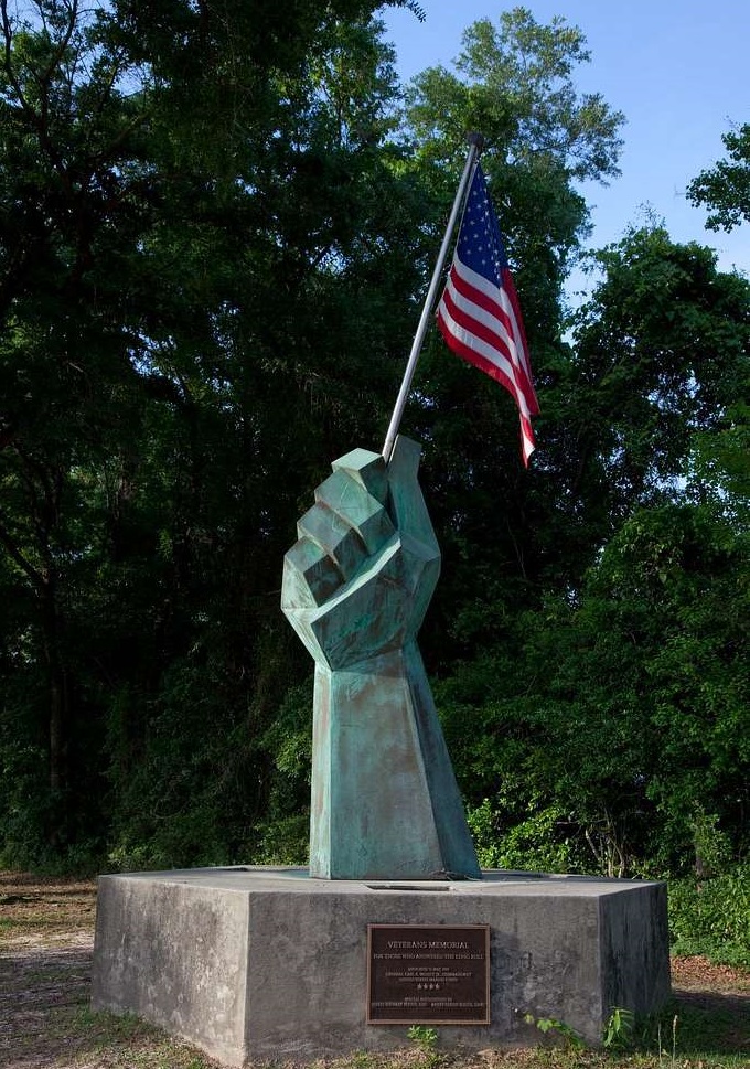 Veterans Memorial Statue in Daphne, Alabama. A greened copper sculpture of a hand holding the flag of the U.S.A.